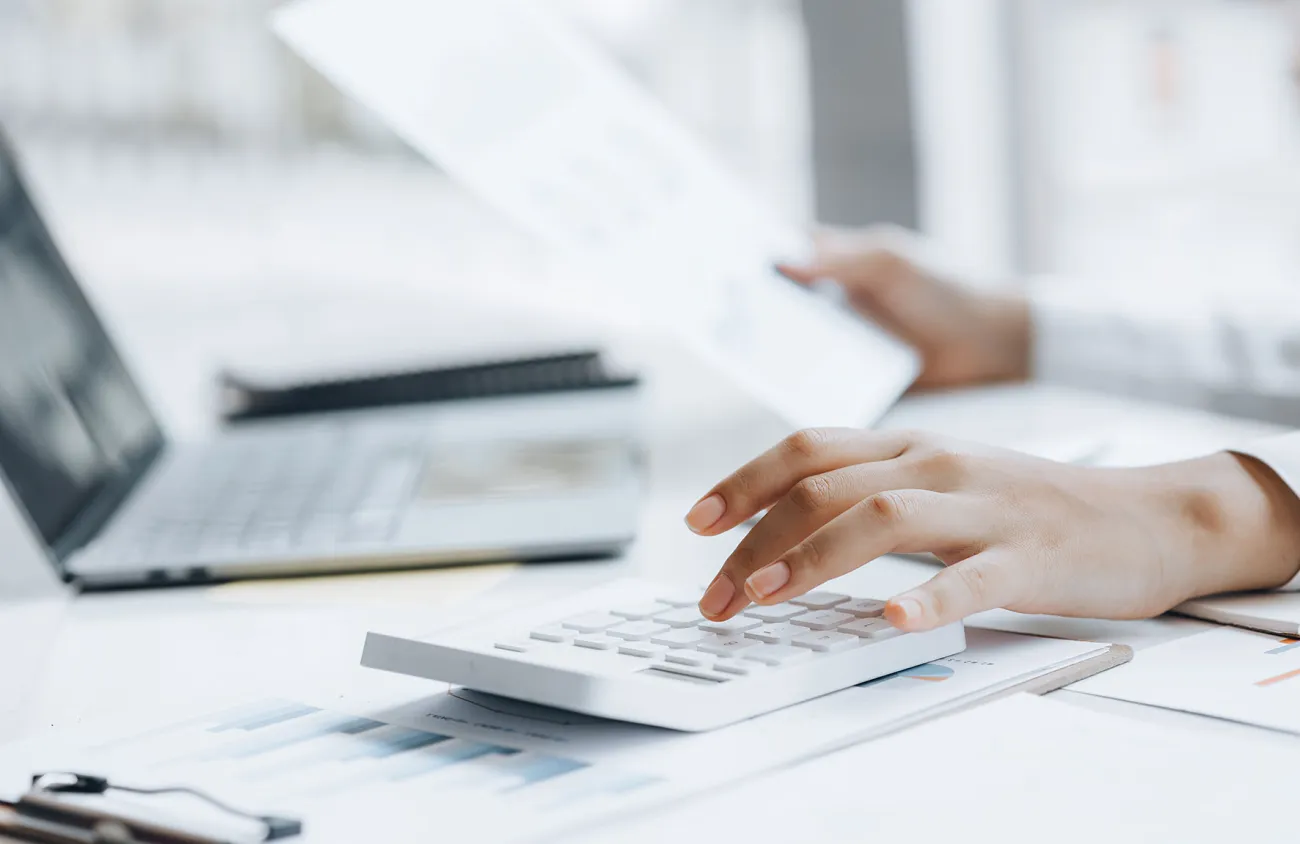 Frau die auf einem Taschenrechner tippt